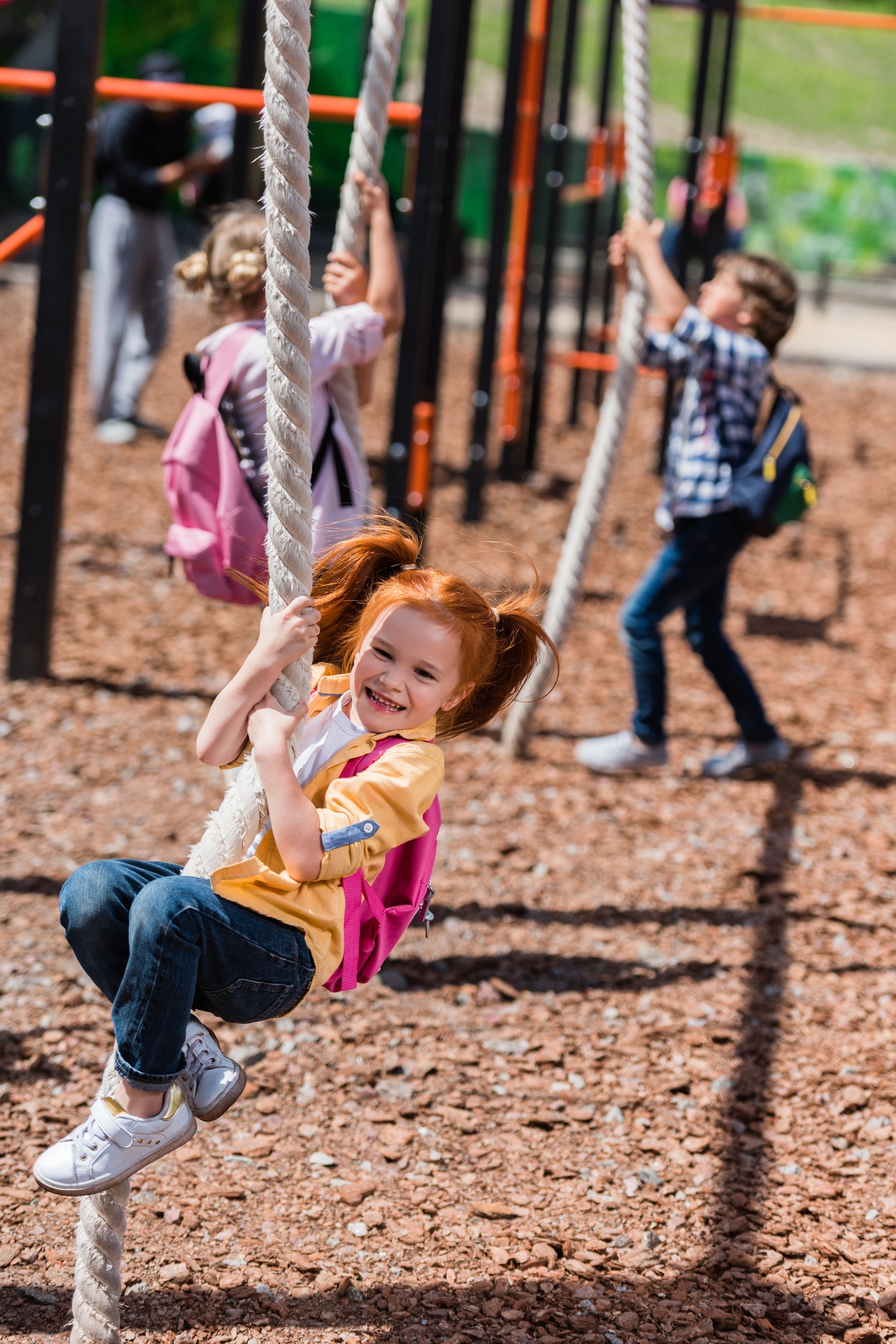 adorable little schoolkids playing with ropes on playground