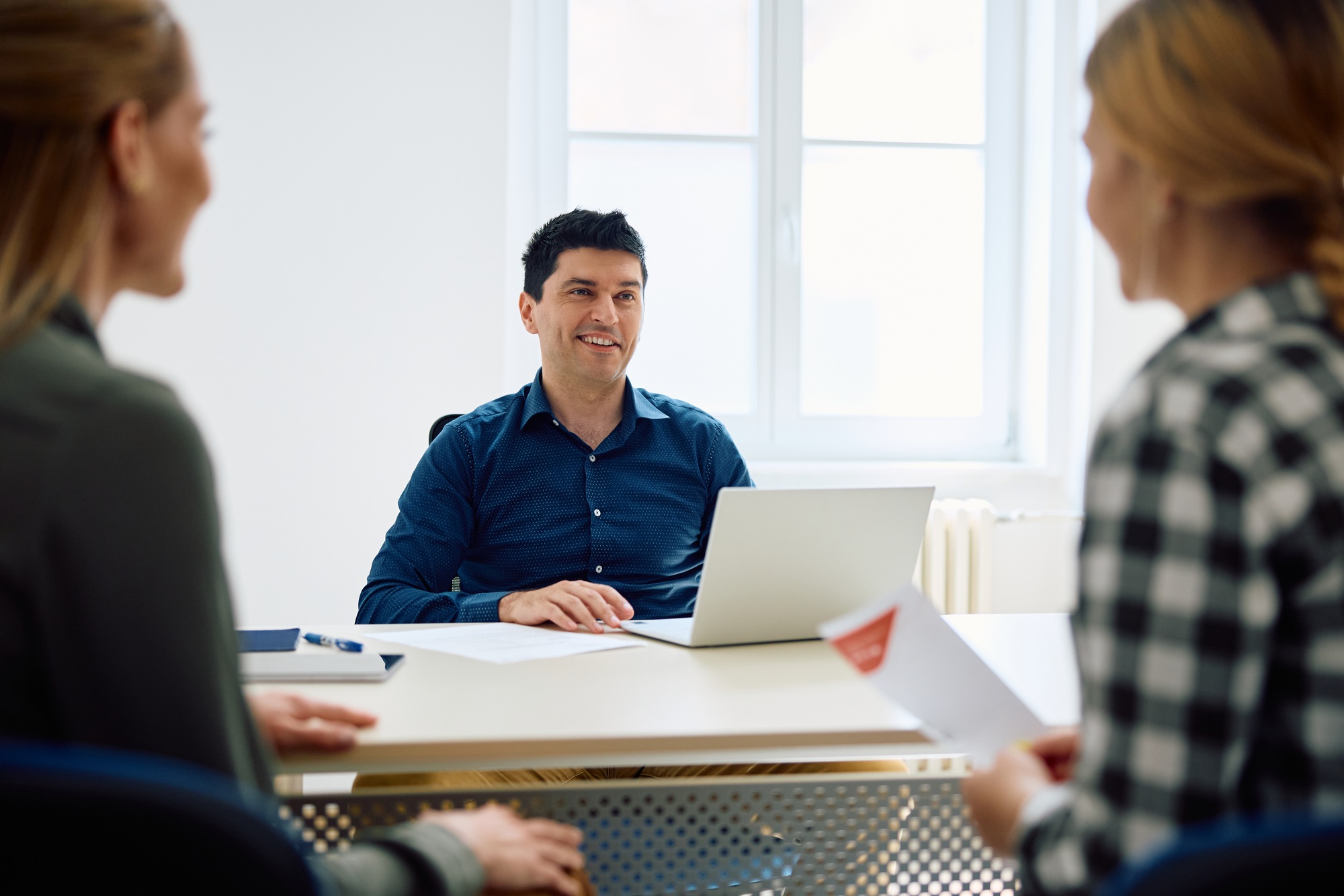 Happy principal having a meeting with mother and daughter at high school.
